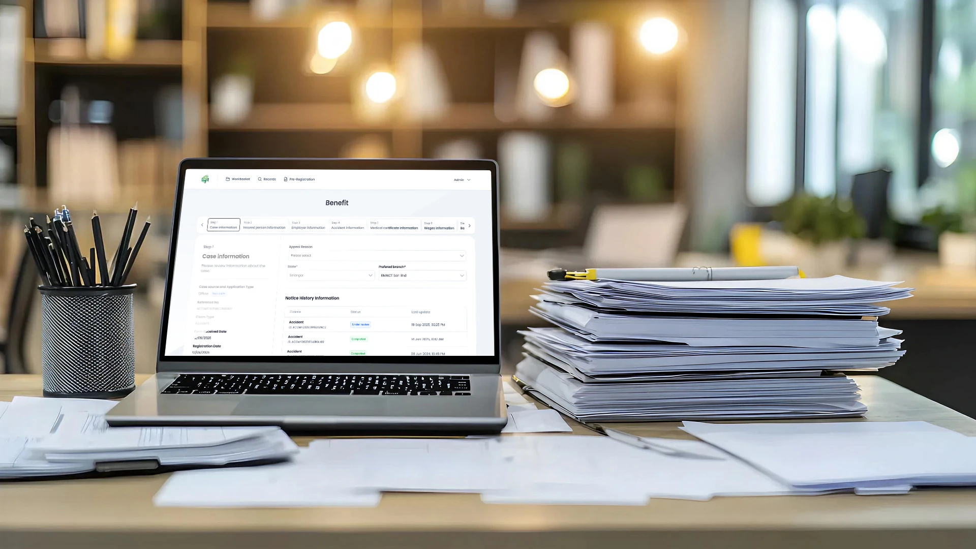 Laptop displaying a digital management interface beside business documents