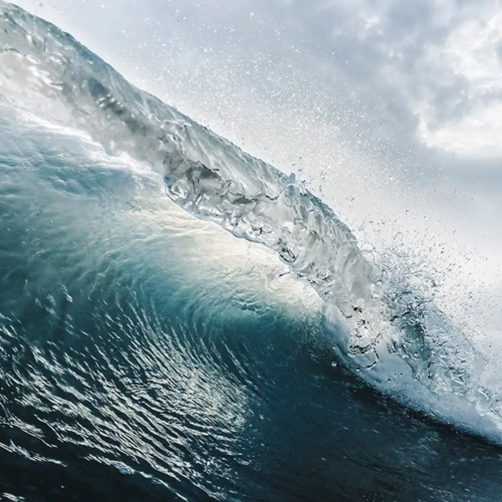 Close-up of a powerful ocean wave with textured blue water