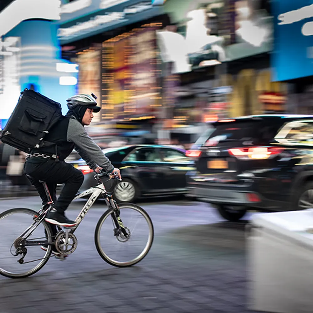 Delivery cyclist travelling through a busy urban street